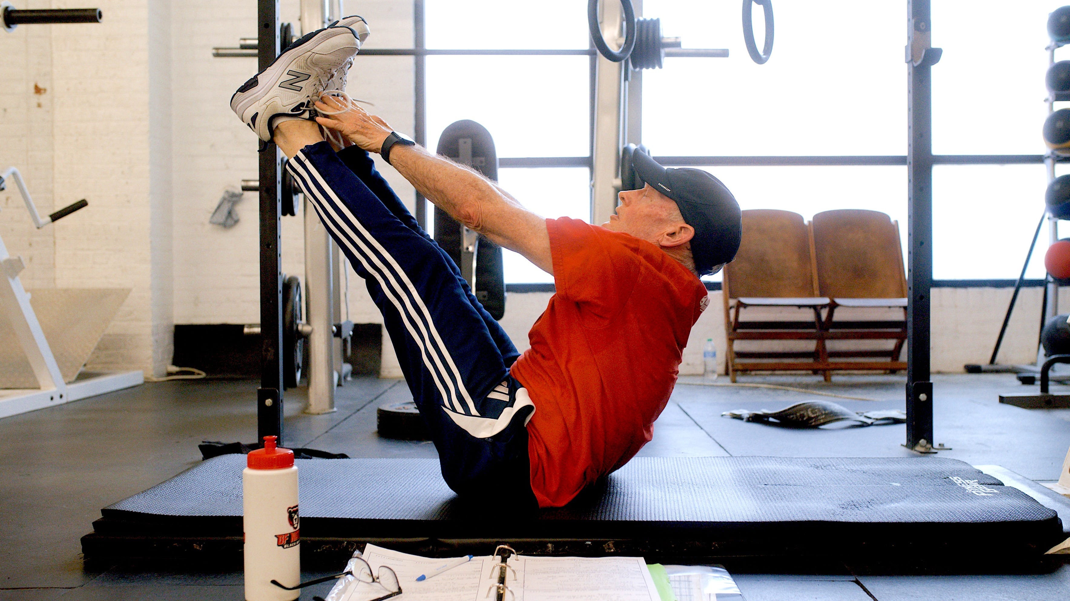 An older man doing a V-up core exercise.