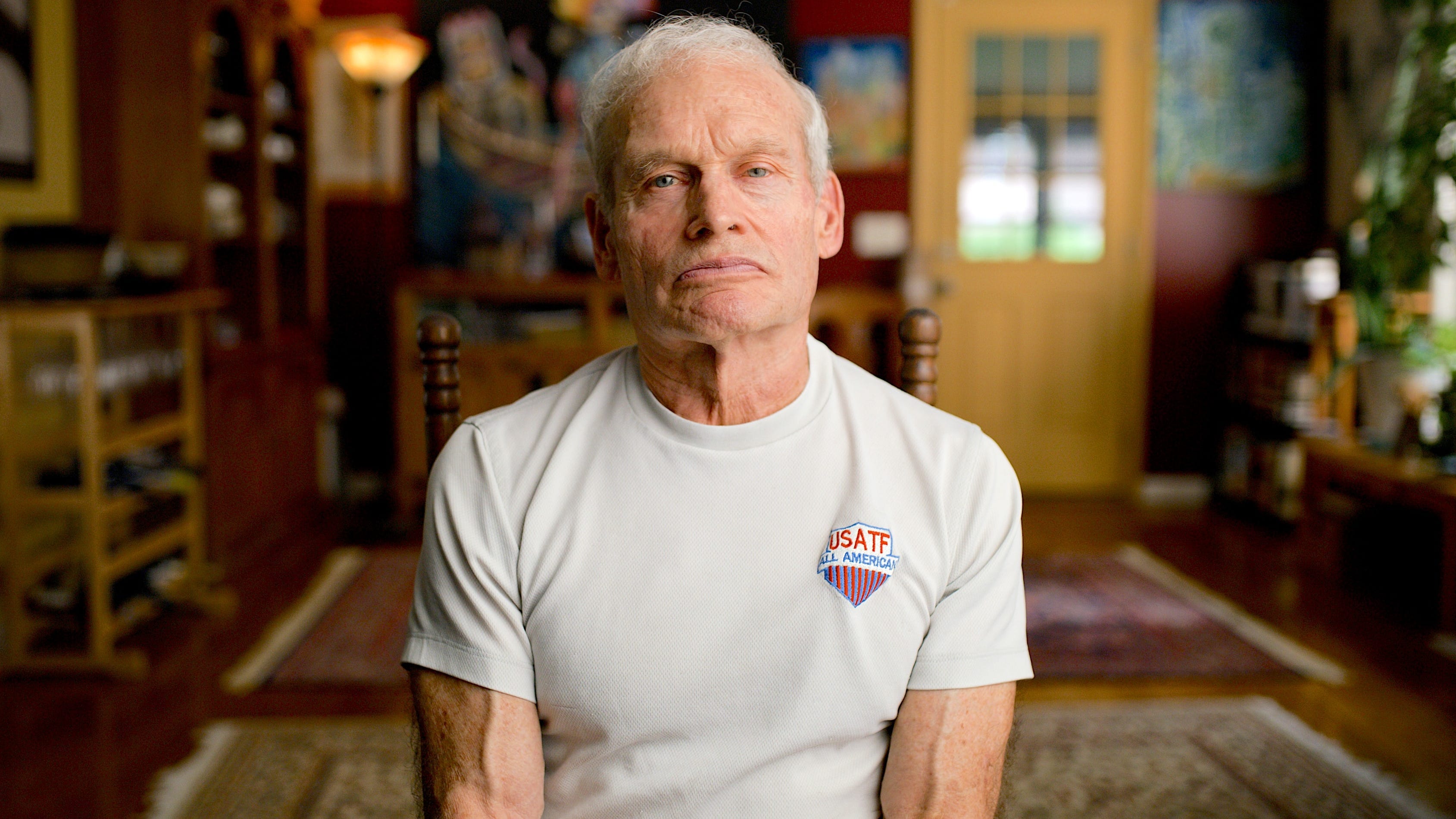 Tom Rauscher sitting in a chair in his home.