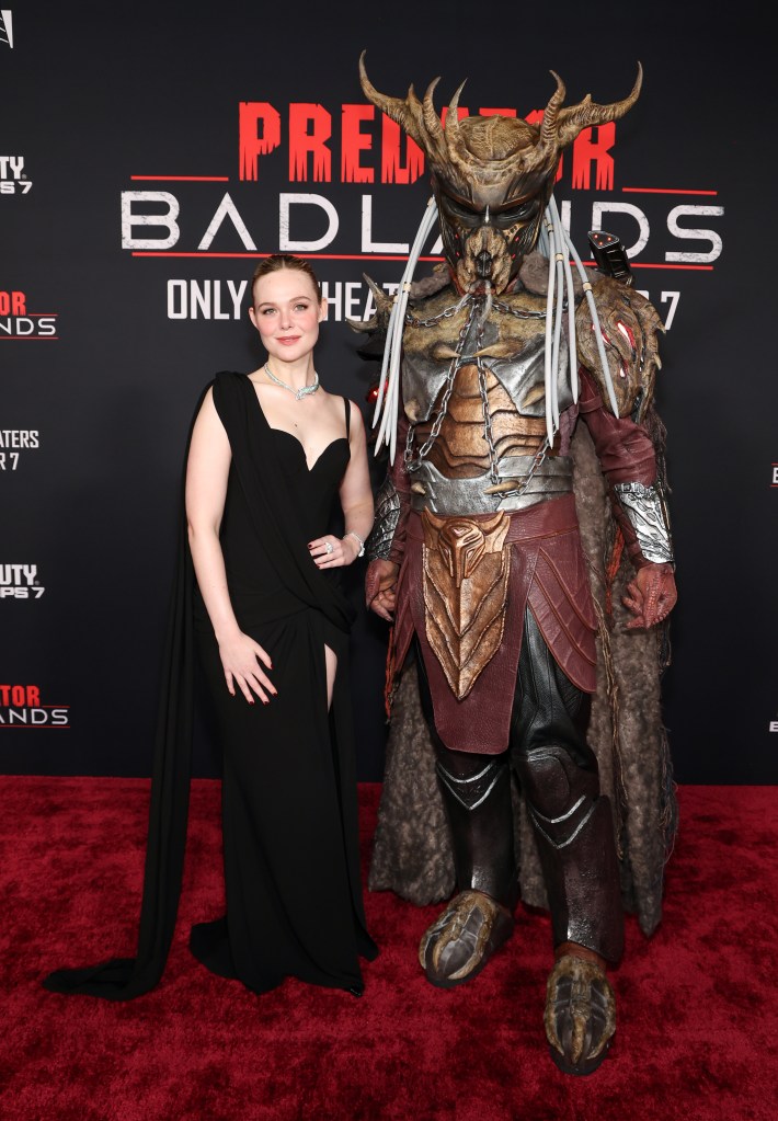 Elle Fanning poses with 'Father' at the premiere of Predator: Badlands in Los Angeles.
