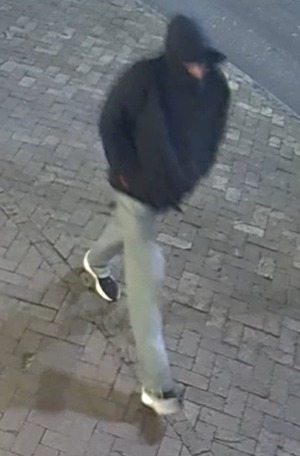 Owen Tillman Kenney, a 19-year-old college student, wearing a dark hooded jacket, light pants, and athletic shoes, walks on a brick-paved surface.