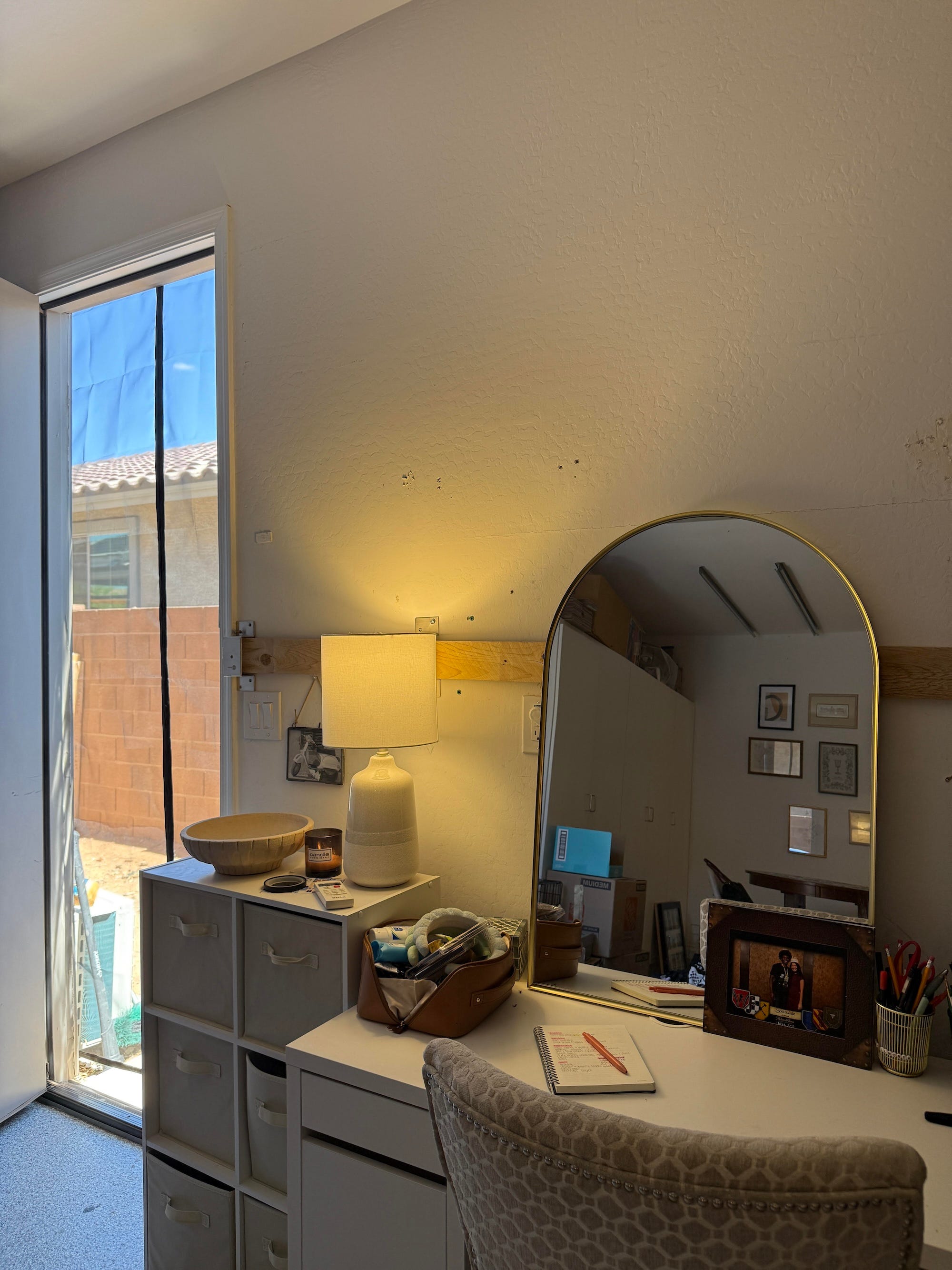 A vanity sits next to a door with a screen on it.