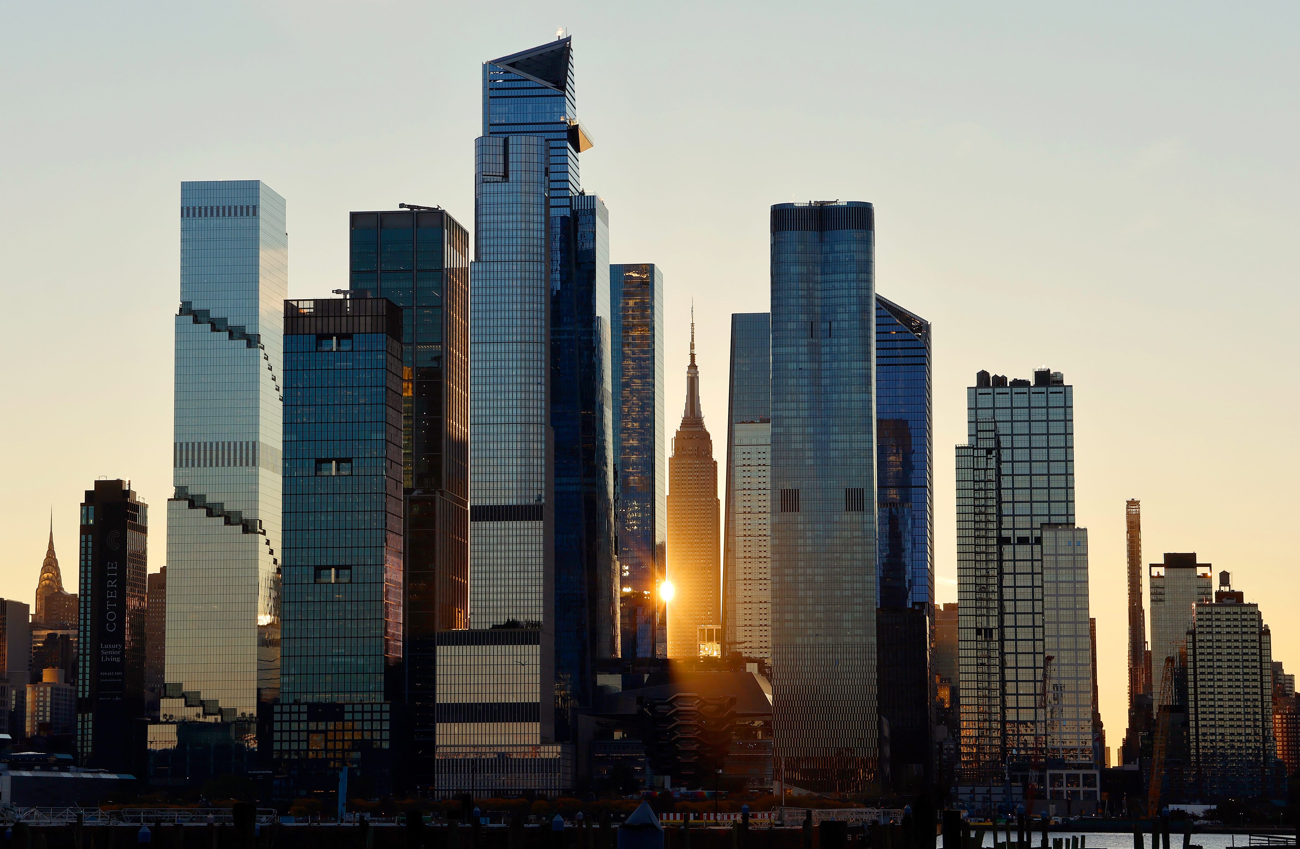 New York City skyline with sun coming up between buildings