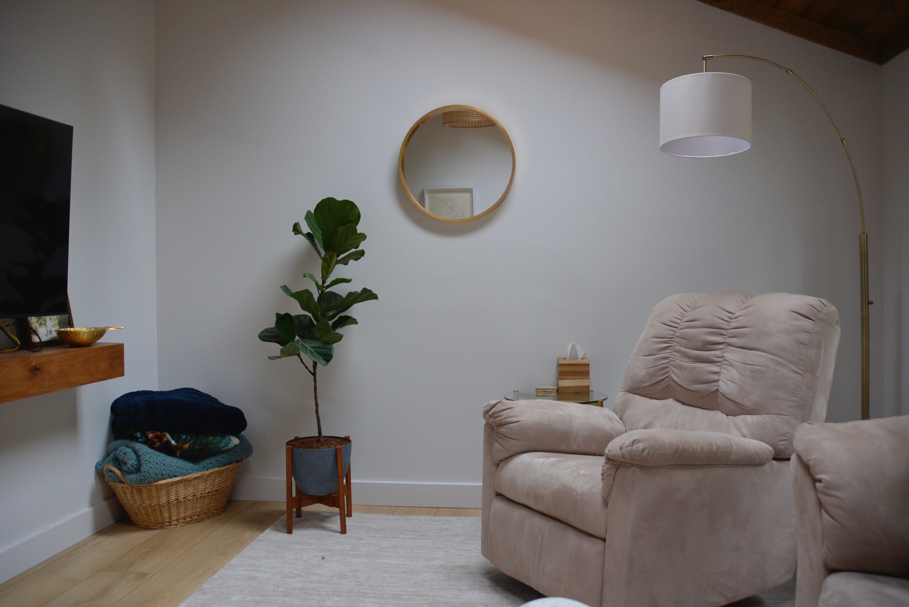 Small round mirror and plant against white wall