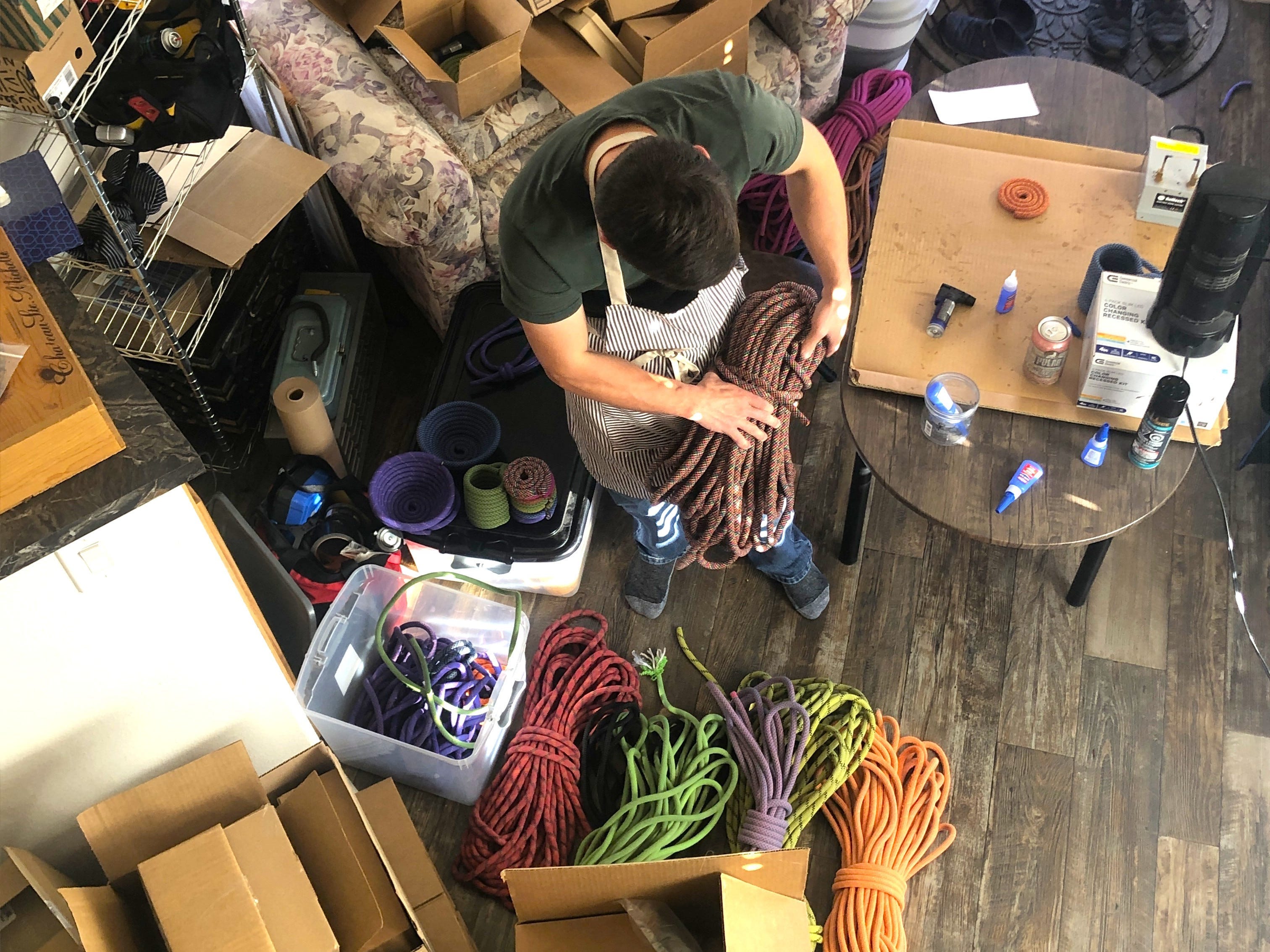 Aerial view of person packaging items in small,  cluttered space
