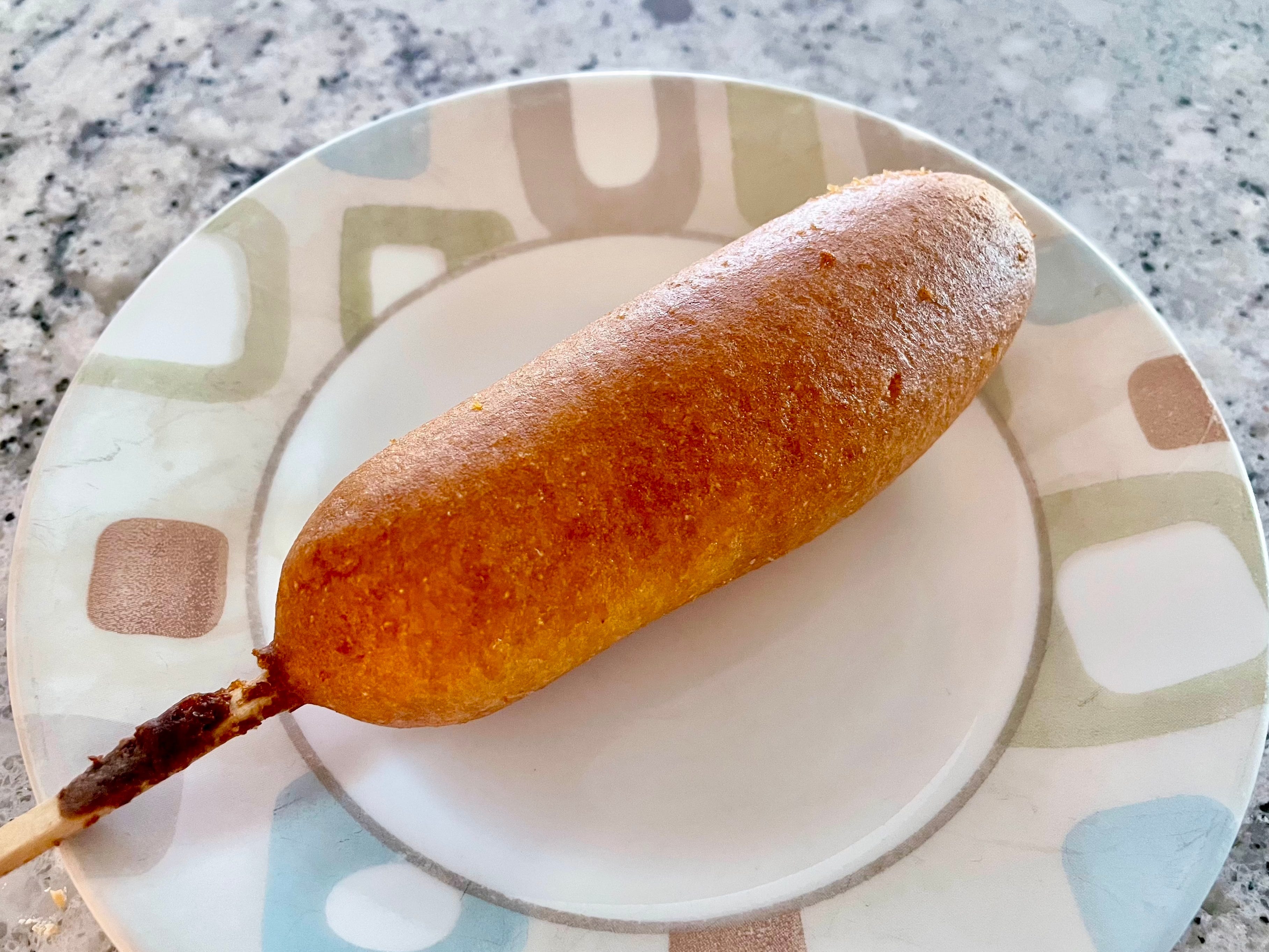 A Crav'n Flavor corn dog on a plate.