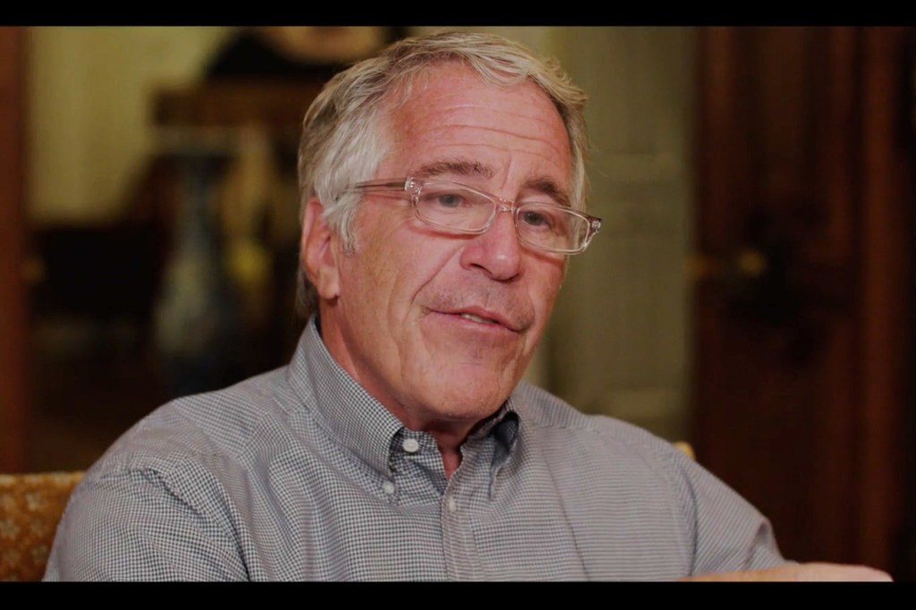 Jeffrey Epstein in a light-colored checkered shirt and clear glasses.