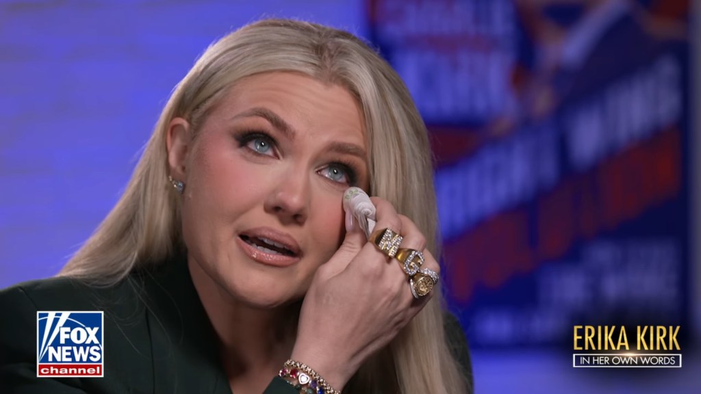 Erika Kirk crying and wiping her eye with a tissue.
