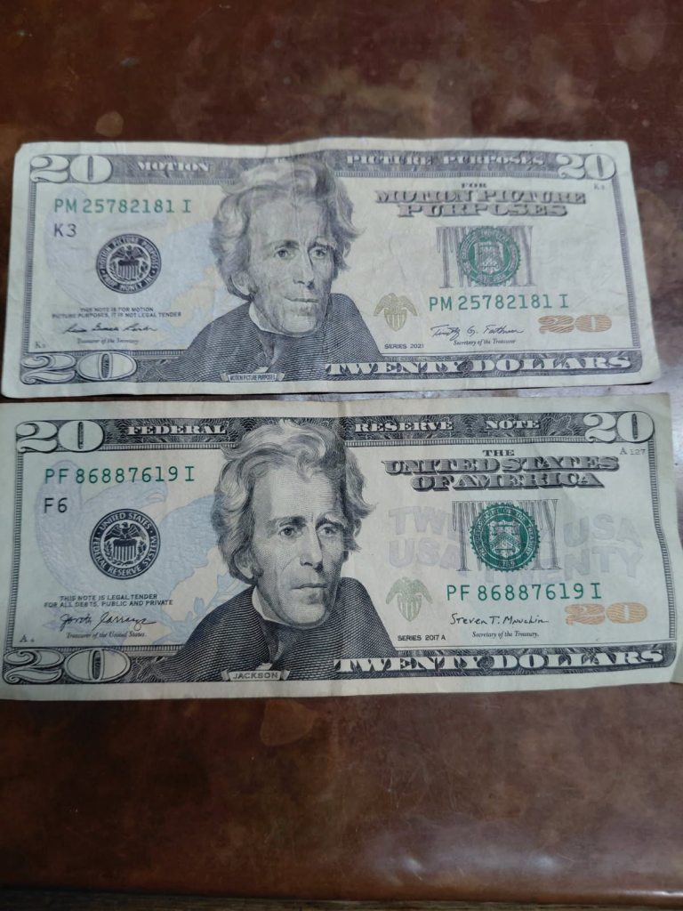 Two twenty-dollar bills, one a prop for motion pictures and one real, featuring Andrew Jackson.
