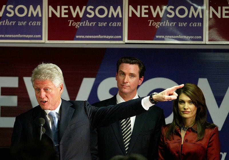Former U.S. President Bill Clinton (L) speaks at a campaign rally for San Francisco mayoral candidate Gavin Newsom (C) as Newsom's wife Kimberly Guilfoyle-Newsom (R) looks on December 8, 2003 in San Francisco, California. Newsom is facing a run-off election against Green Party candidate Matt Gonzalez on December 9th.