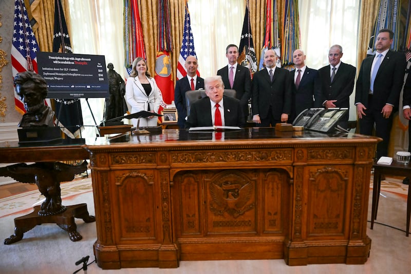 President Donald Trump sits behind his desk as he makes an announcement in the Oval Office of the White House on November 6, 2025.