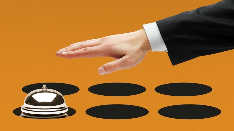 Illustration of a hand reaching for a hotel bell on a field of black circles