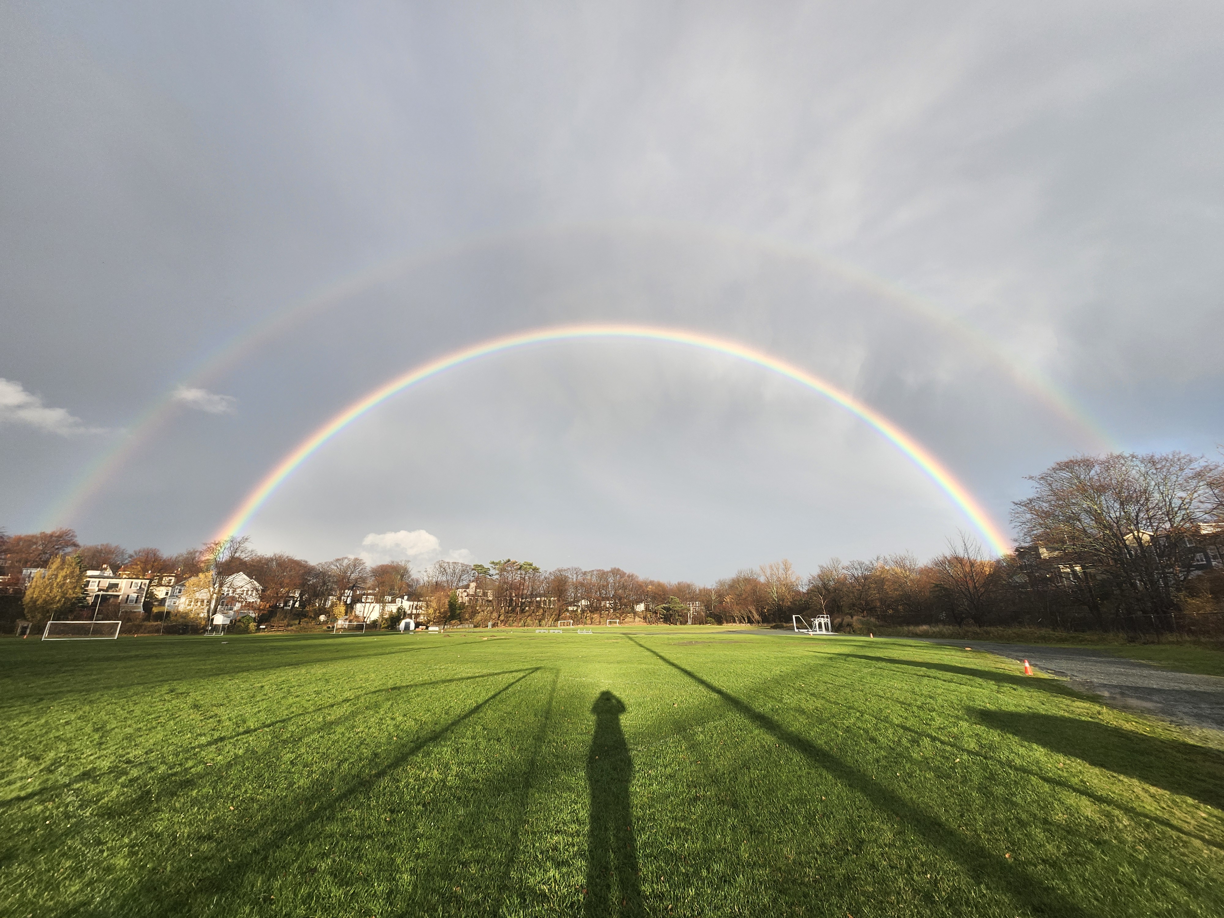 A double rainbow with the silhouette of a person
