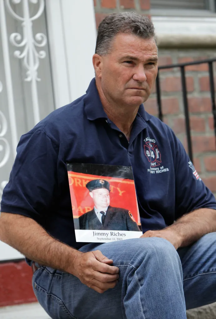 Retired firefighter Jim Riches sits while holding a photograph of his deceased son, also a firefighter.
