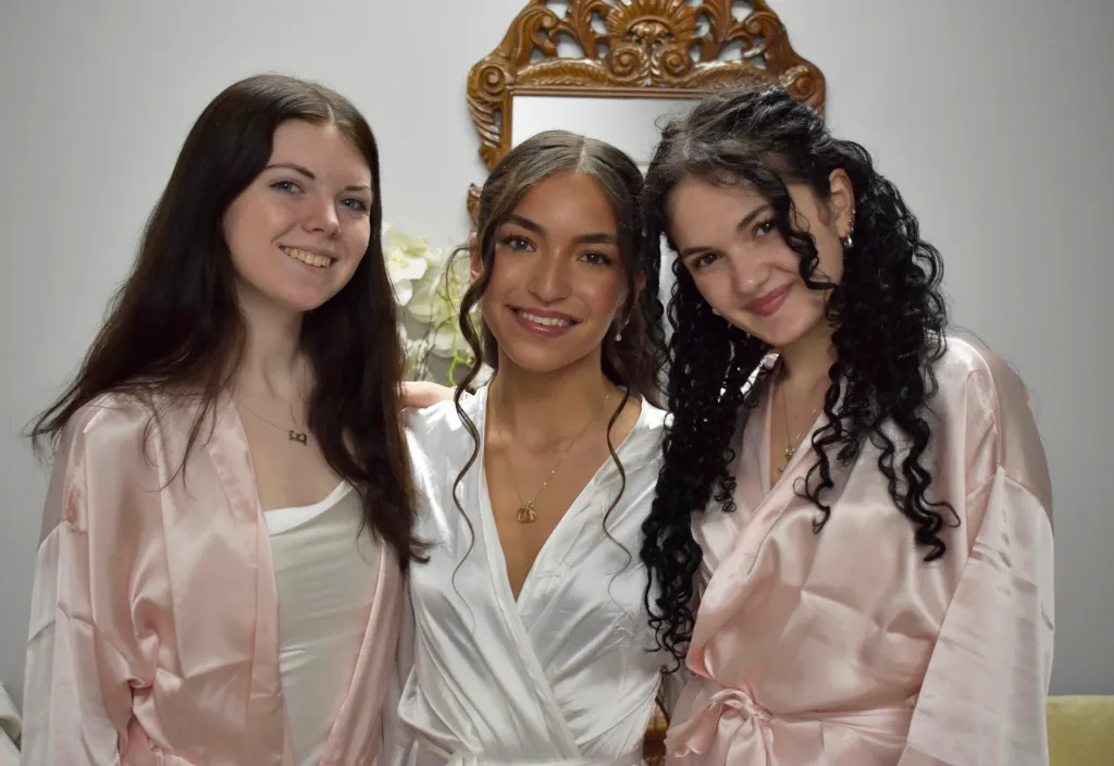 Three young women, Emily Finn, Maya Truglio, and Brynne Truglio, posing for a photo.
