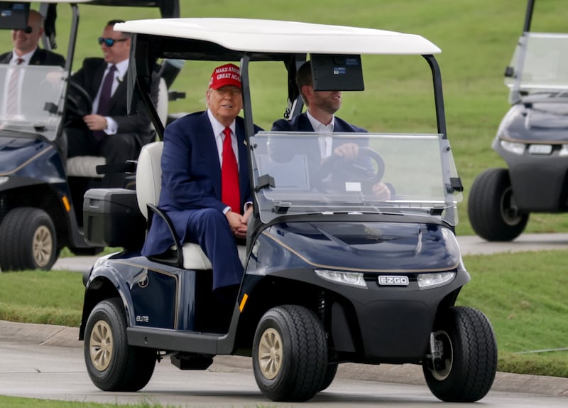 DORAL, FLORIDA - APRIL 03: U.S. President Donald Trump and his son, Eric Trump, drive in a golf cart after he arrived on Marine One at the LIV Golf tournament being held at his Trump National Doral Golf Club on April 03, 2025 in Doral, Florida. Yesterday, Trump declared a U.S. economic emergency and announced sweeping tariffs of at least 10%, with rates even higher for 60 countries that have a high trade deficit with the U.S. The tariffs will affect electronics, automobiles, clothing and shoes, wines and spirits, and Swiss watches (Photo by Joe Raedle/Getty Images)