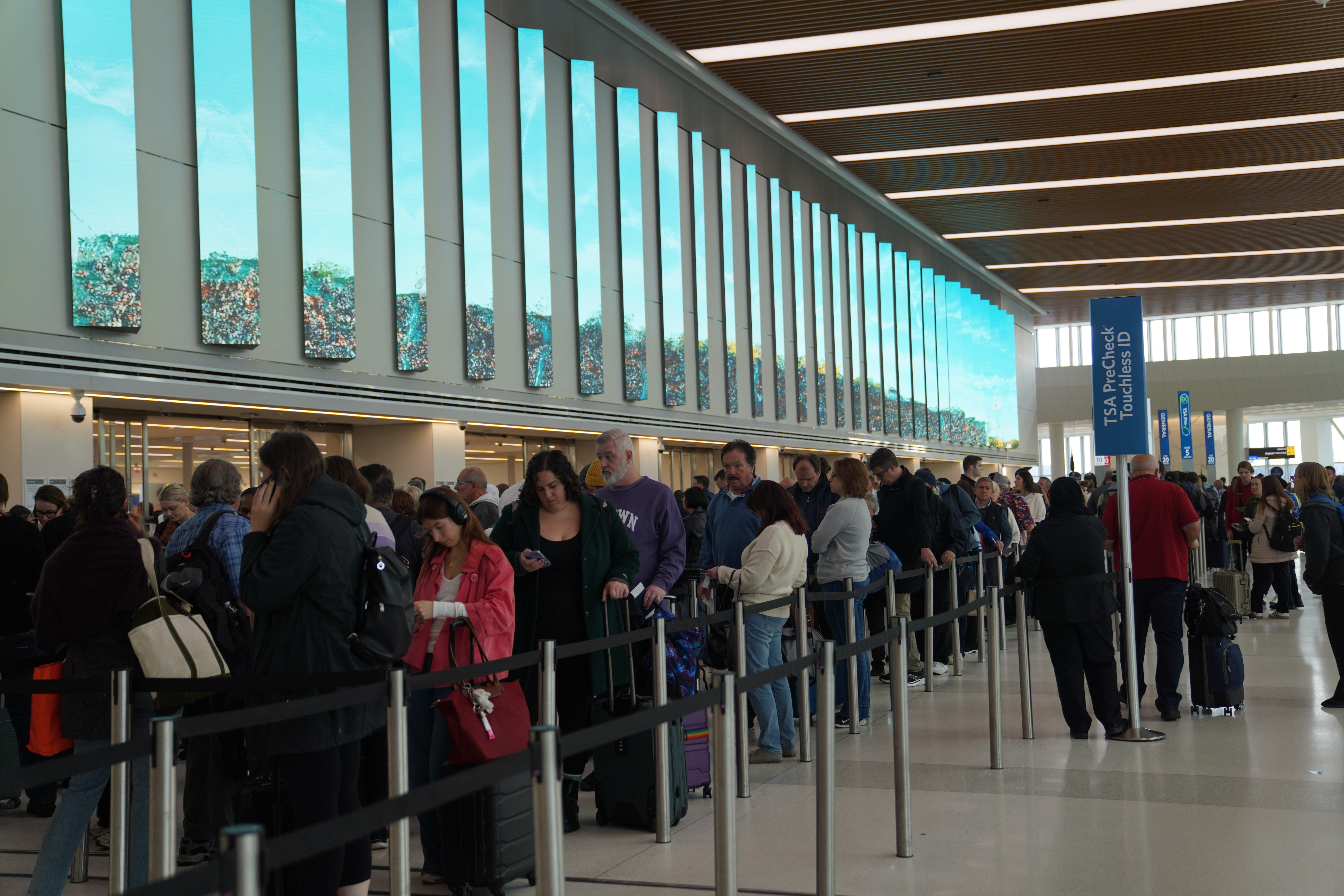 Passengers line up to check in at the LaGuardia Airport in New York, the United States, on Oct. 31, 2025.