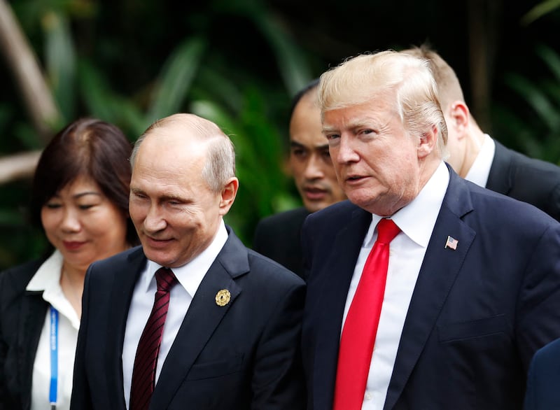 US President Donald Trump (R) and Russia's President Vladimir Putin walk together to take part in the "family photo" during the Asia-Pacific Economic Cooperation (APEC) leaders' summit in the central Vietnamese city of Danang on November 11, 2017. World leaders and senior business figures are gathering in the Vietnamese city of Danang this week for the annual 21-member APEC summit. (Photo by JORGE SILVA / POOL / AFP) (Photo by JORGE SILVA/POOL/AFP via Getty Images)