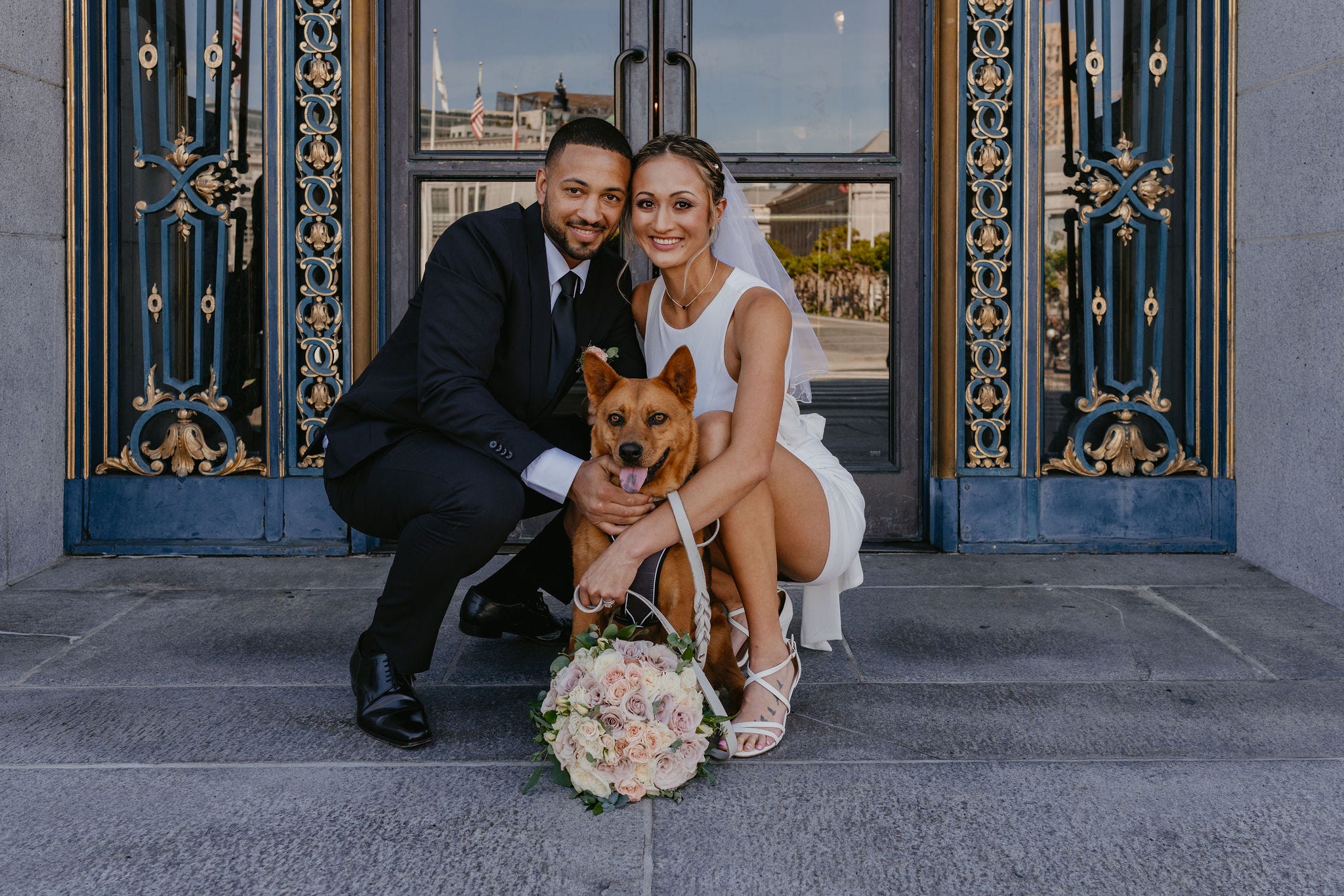 Ali and Aislyn Benjamin, posing with their dog on their wedding day.