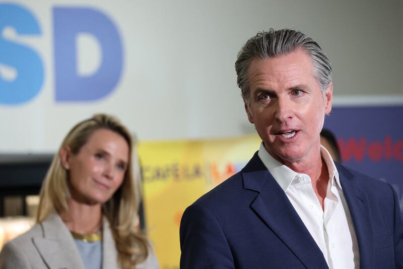 California Governor Gavin Newsom speaks at Belvedere Middle School in Los Angeles on October 8, 2025 as his wife Jennifer Siebel-Newsom looks on.