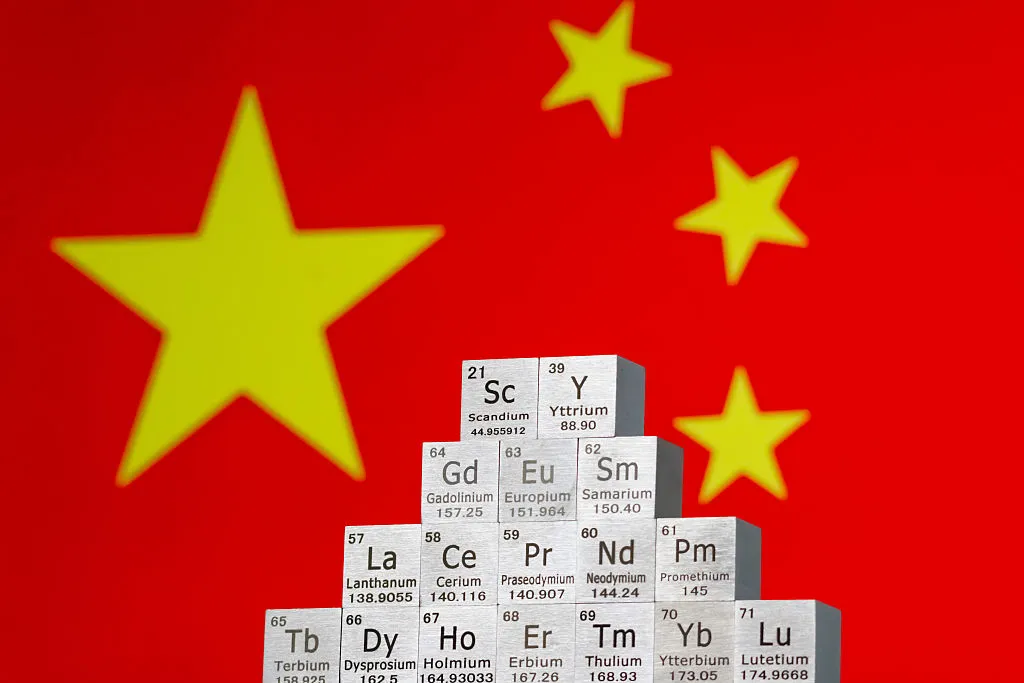 Rare earth element cubes stacked in front of Chinese flag