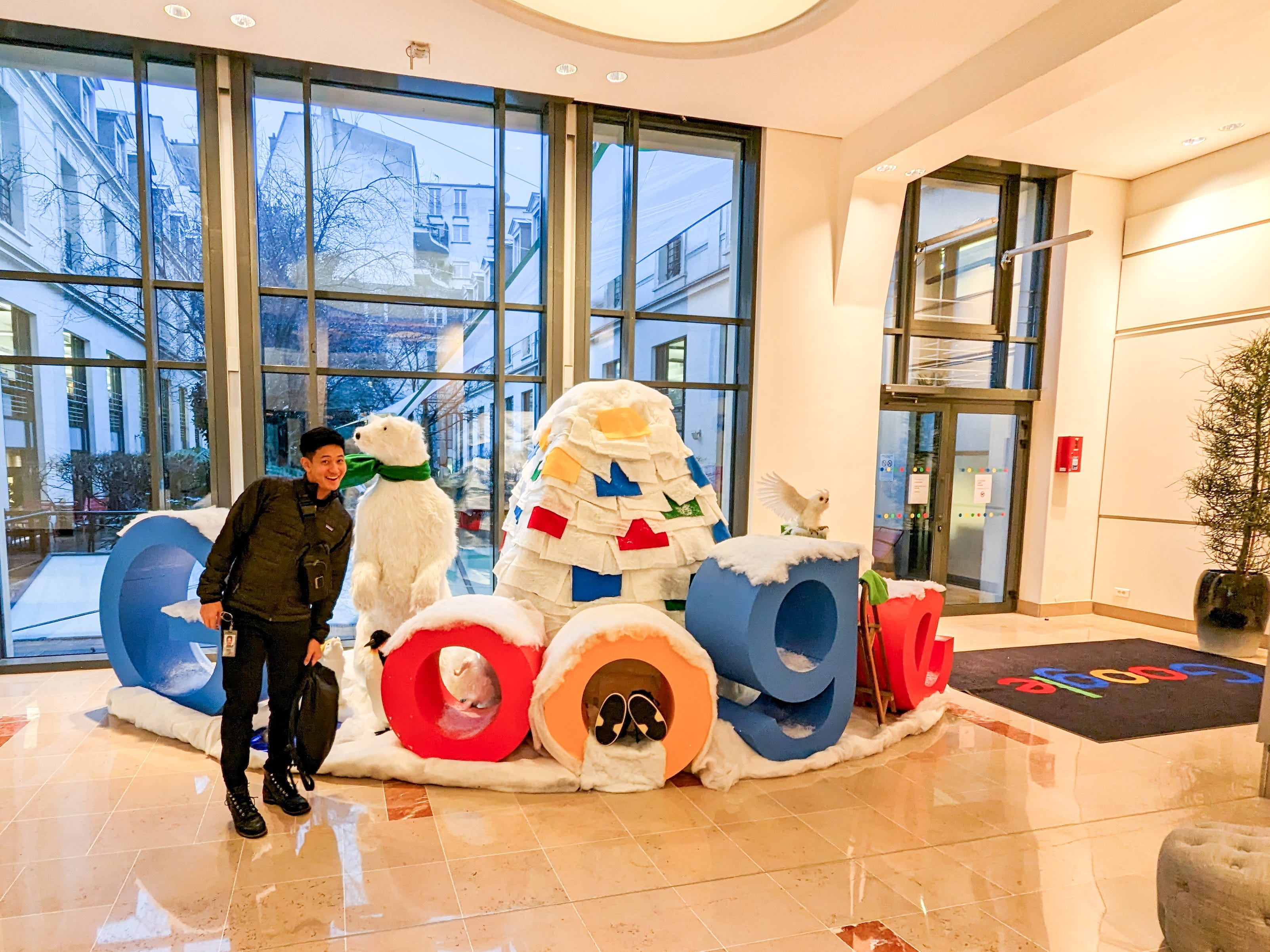 Kento poses near a winter-themed Google logo set up in an office building.
