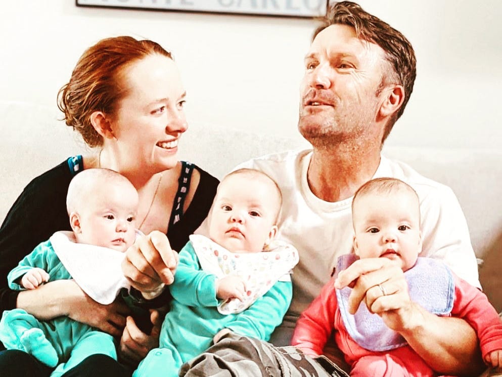 The author and her husband pose with their identical triplets.