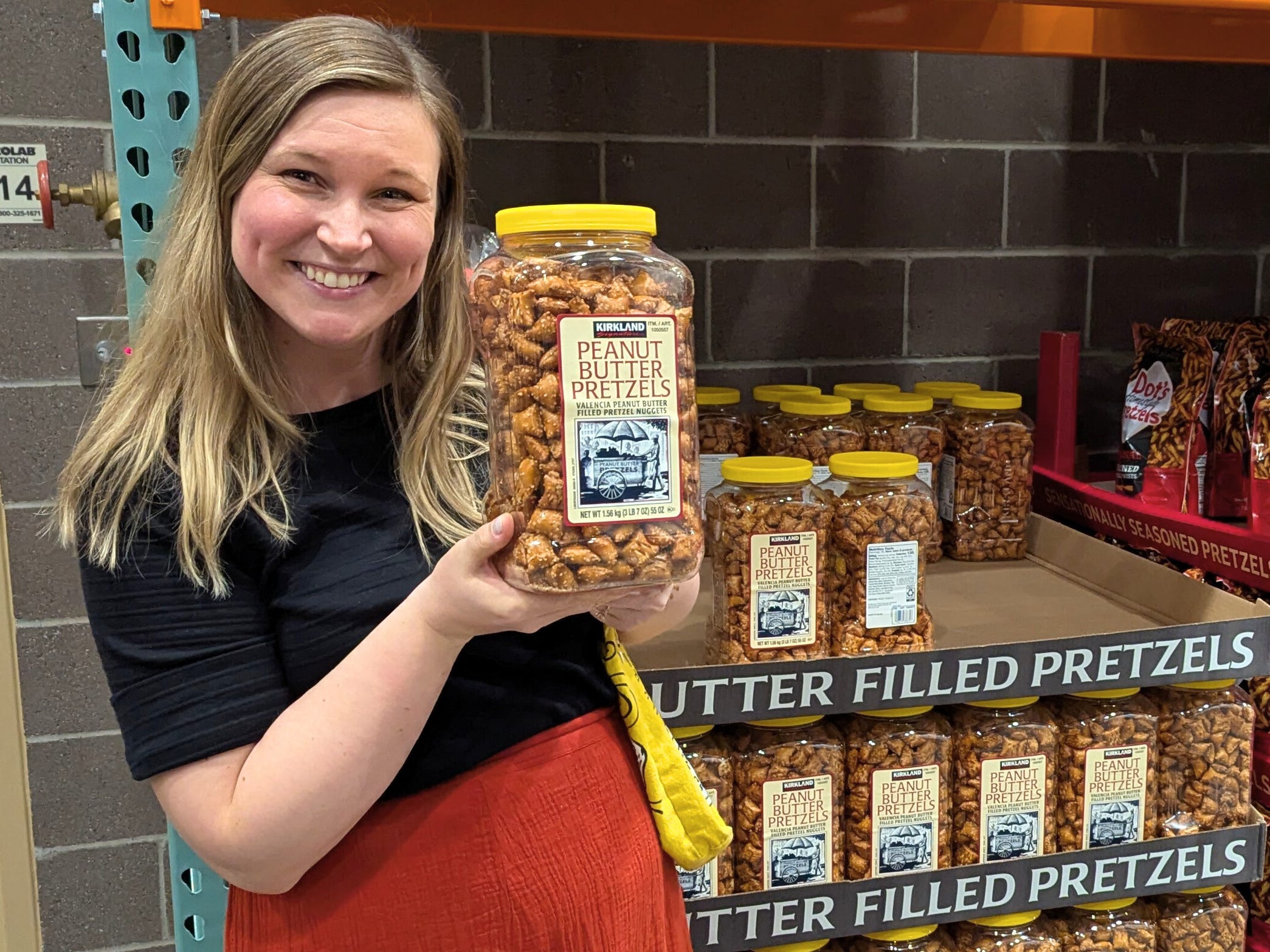 The author posing with a jar of Kirkland Signature peanut butter pretzels.