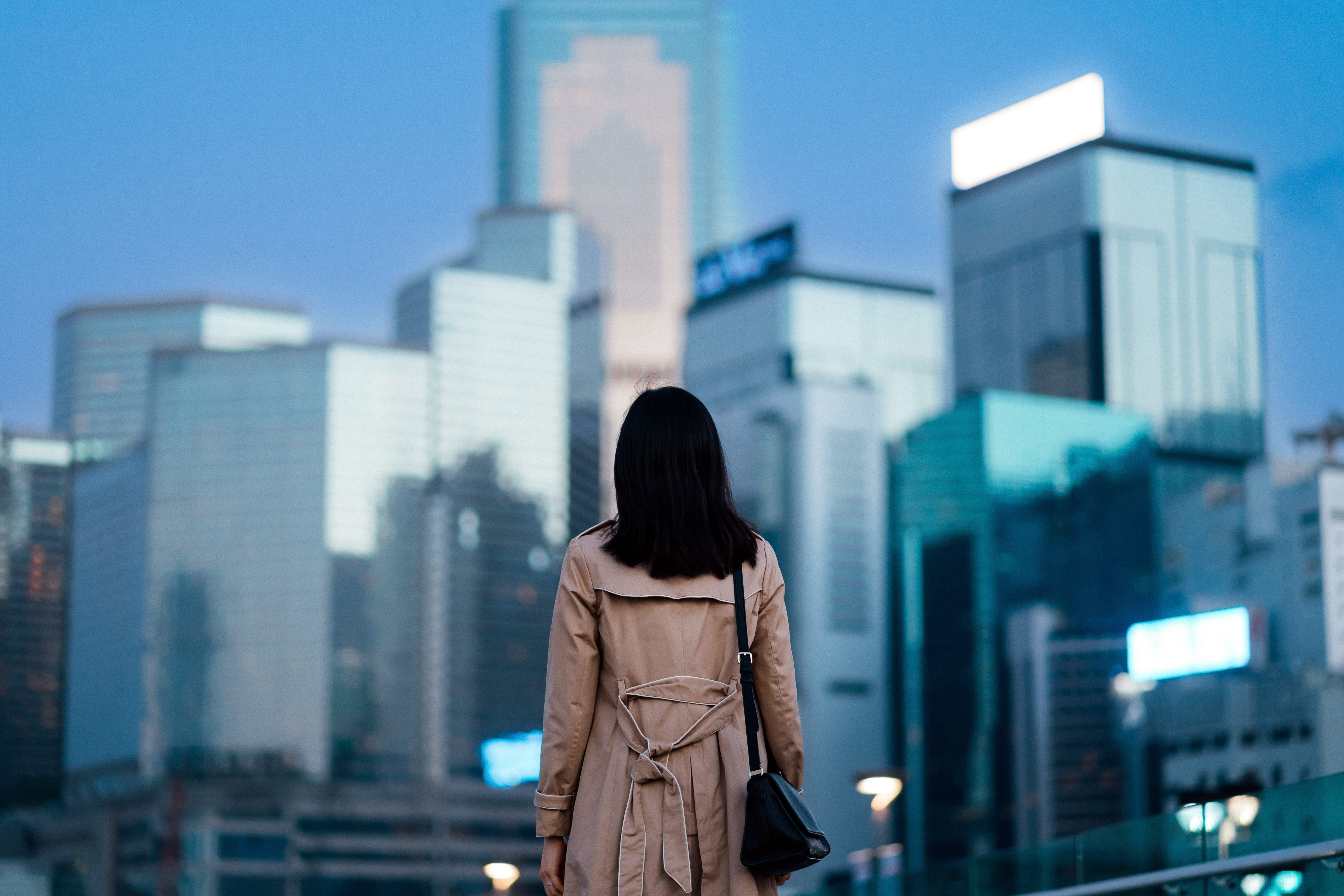 A woman looks at a city skyline.
