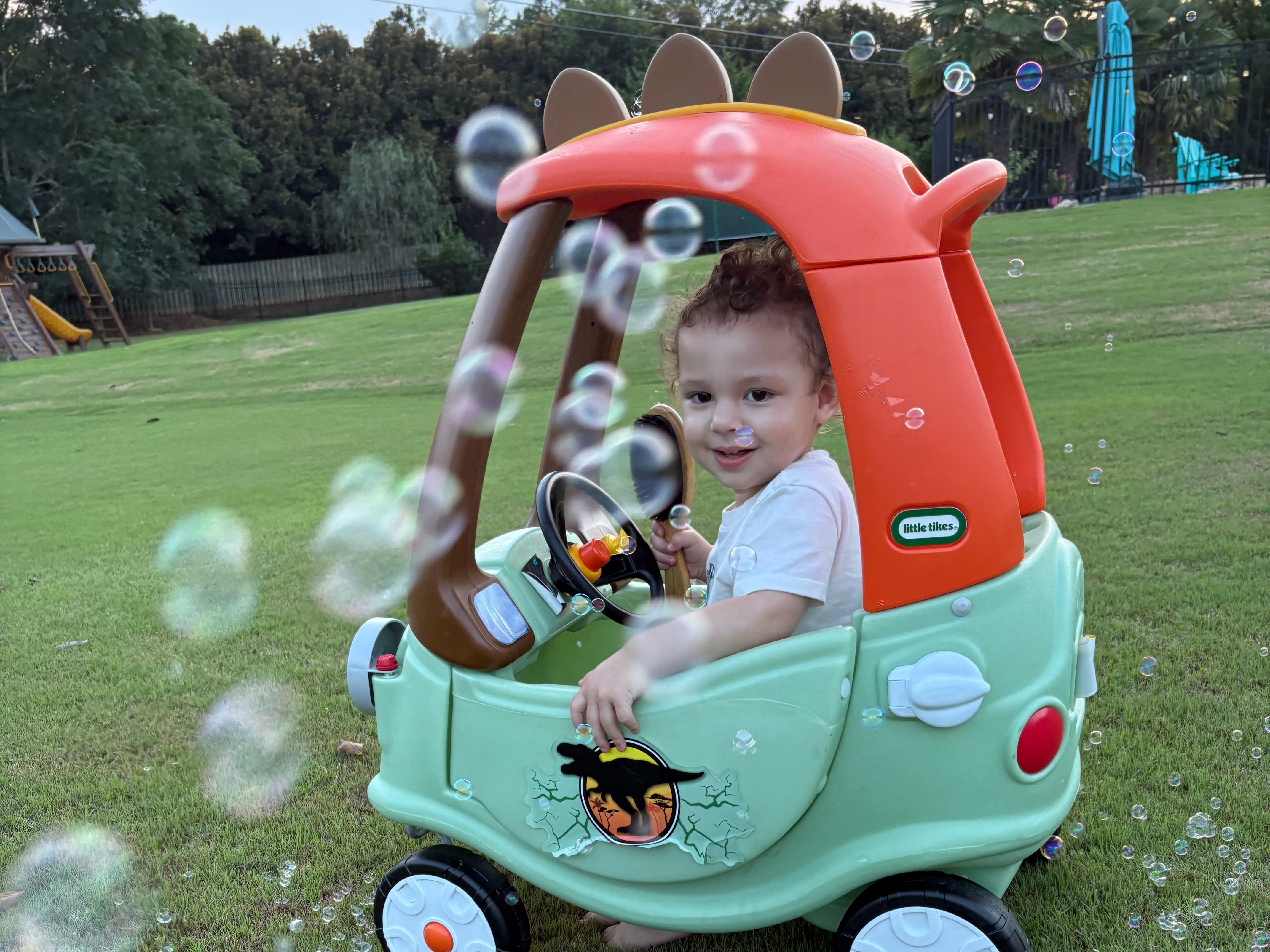 The author's son in a play car blowing bubbles.
