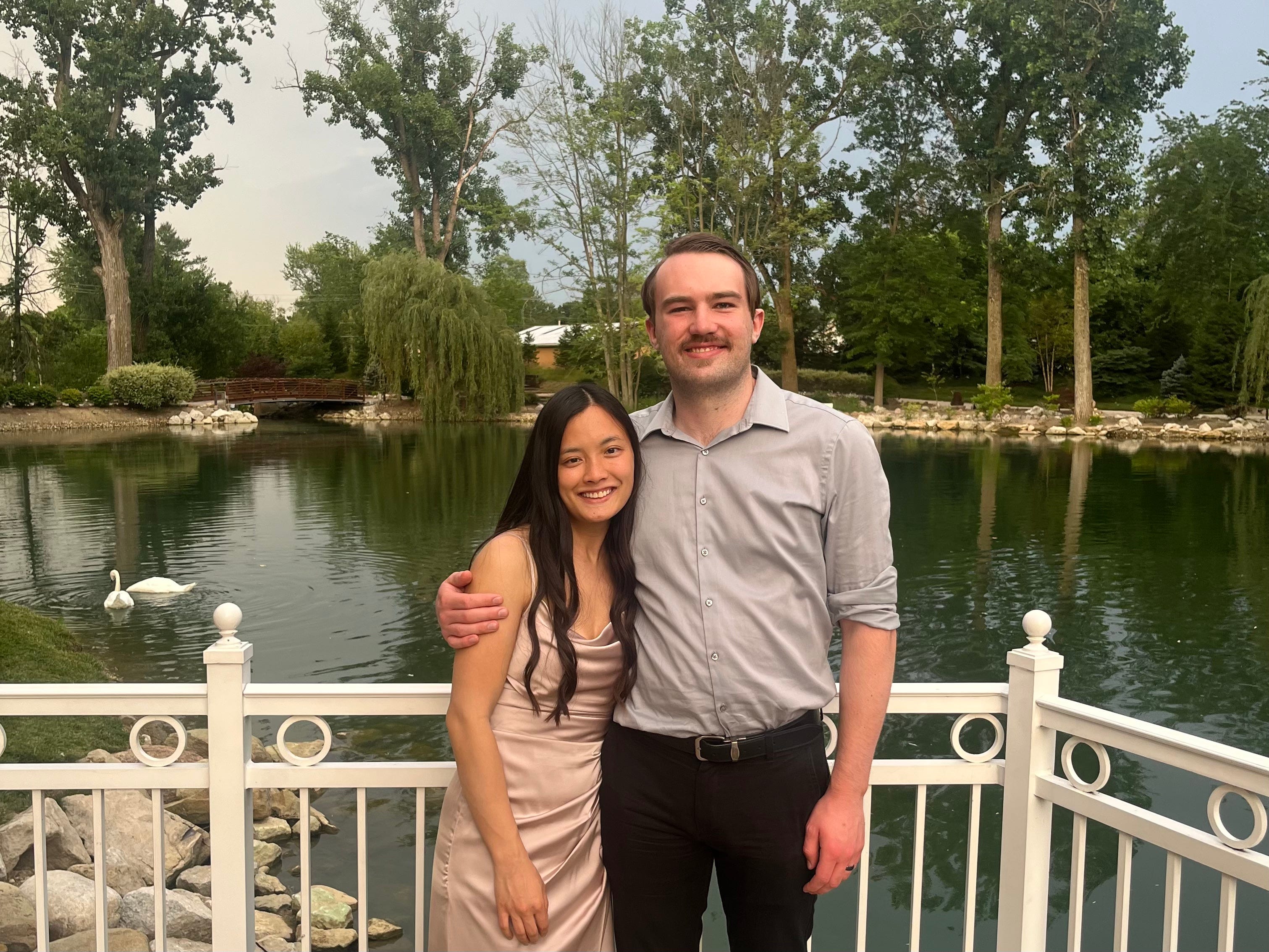 Author Luke Macy and wife Emma smiling in front of water,
