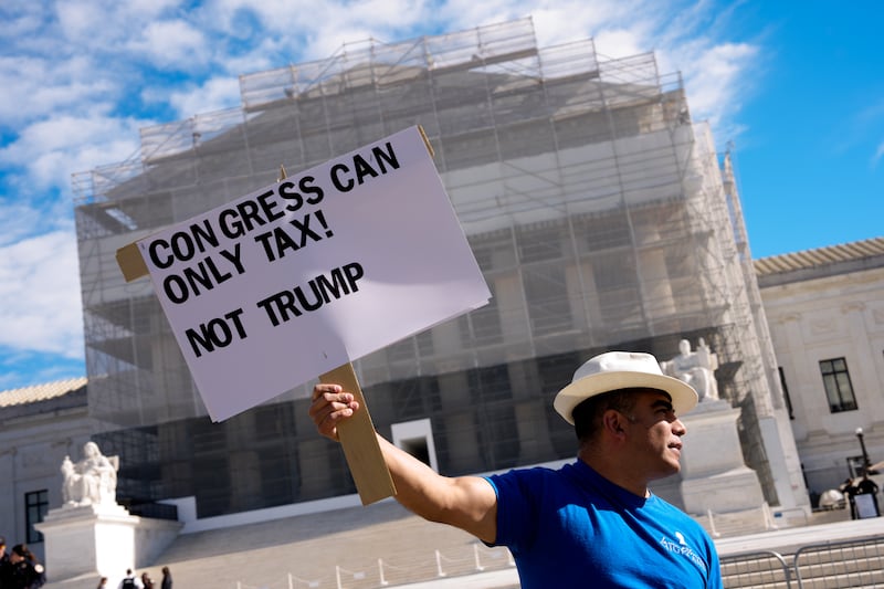 An activist protesting outside the Supreme Court on November 5, 2025 as the high court was set to hear arguments on the legality of Donald Trump's tariffs.