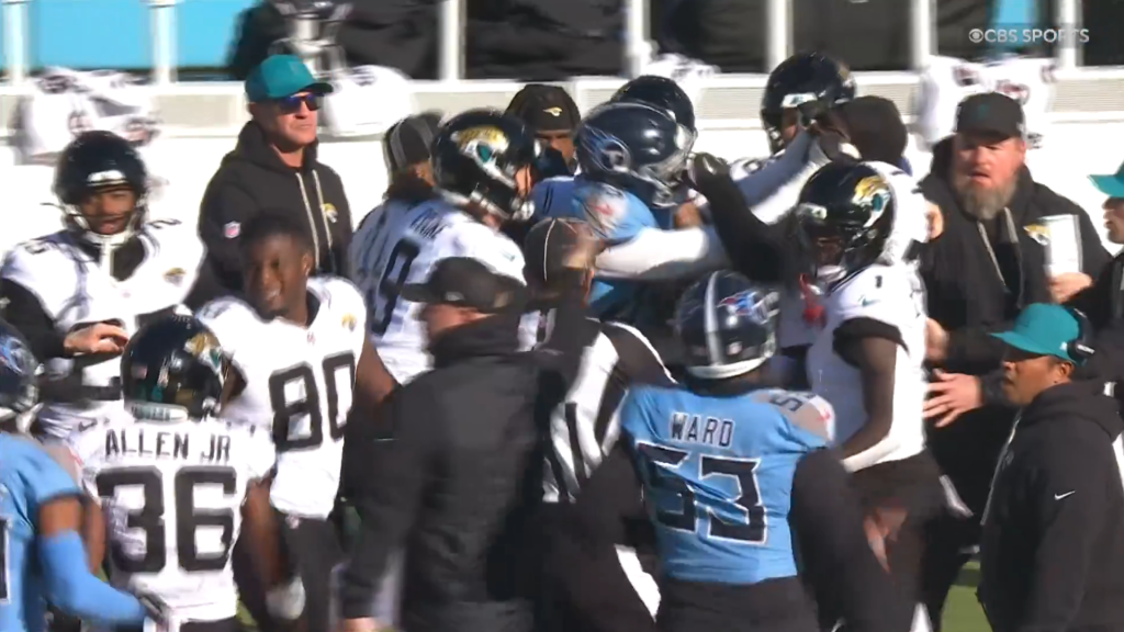 Football players and staff engaged in a heated on-field altercation during a game.