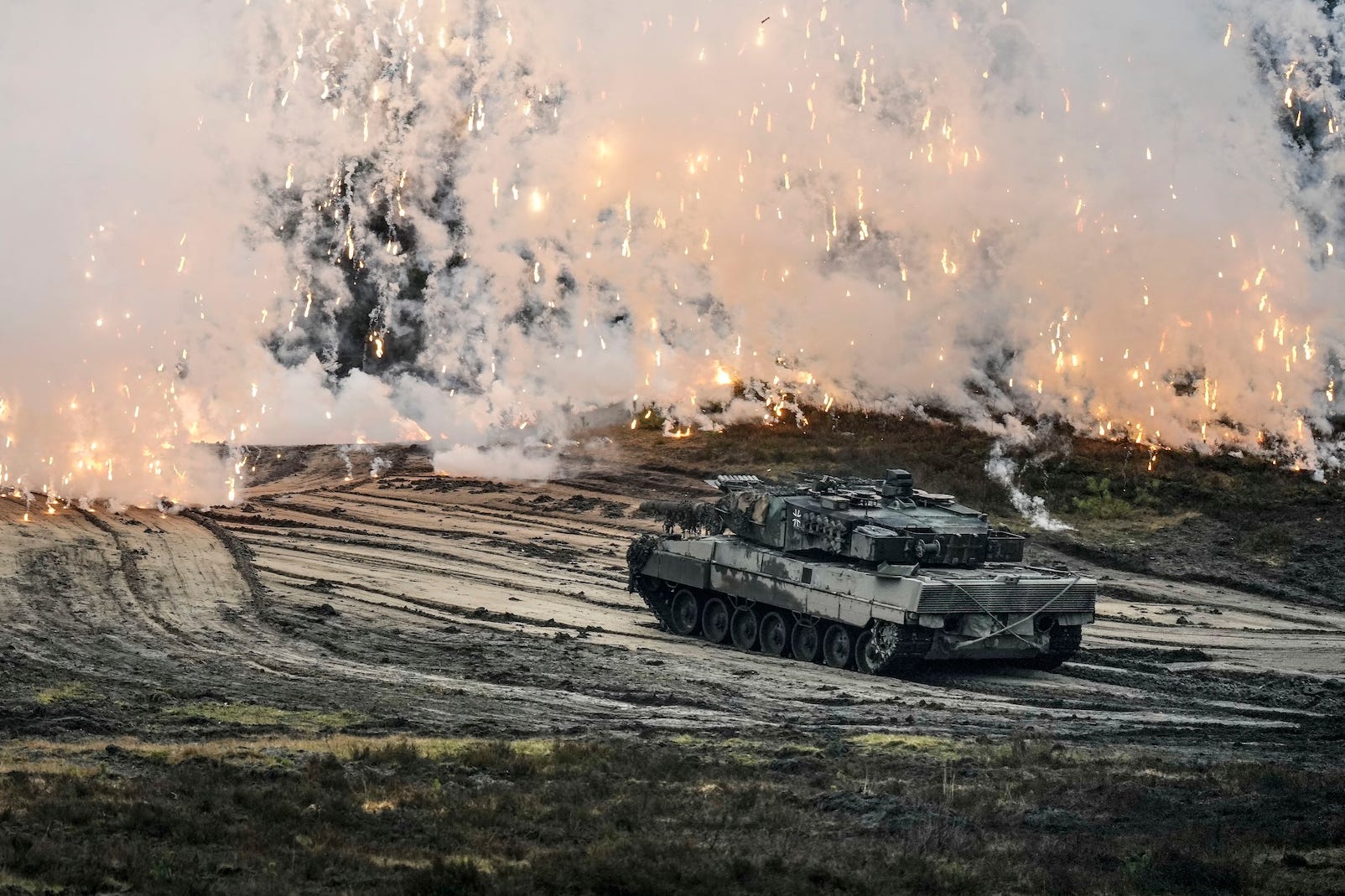 A tank under a sky full of sparks and smoke.