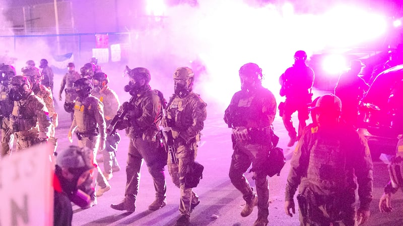 Federal law enforcement agents attack demonstrators protesting outside of an immigrant processing center with a barrage of tear gas and pepper balls
