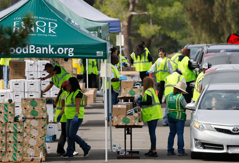 Workers and volunteers help distribute food boxes to those in need at a large-scale drive-through food distribution, in response to the federal government shutdown and SNAP/CalFresh food benefits delays, on November 5, 2025 in City of Industry, California.