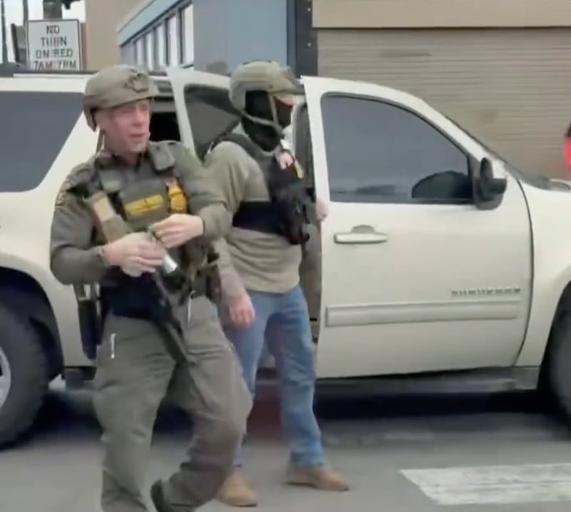 Gregory Bovino unpins a canister of CS gas during the clash in Cicero, Illinois, on November 8, 2025.