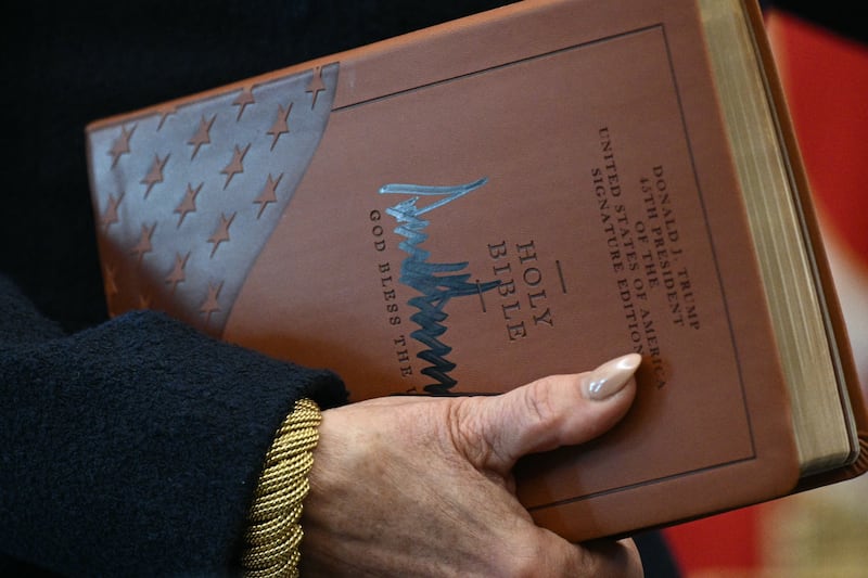 US Attorney for the District of Columbia Jeanine Pirro holds the Holy Bible  signed by Trump before Gor's swearing-in.