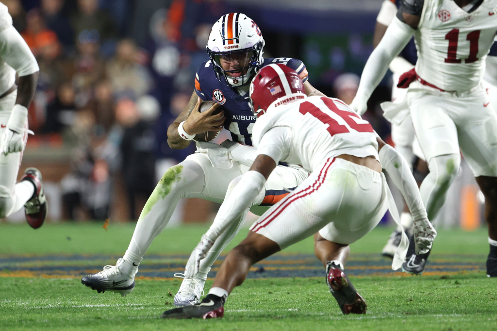 Auburn Tigers quarterback Ashton Daniels (12) runs with the ball against Alabama Crimson Tide defensive back Red Morgan (16).