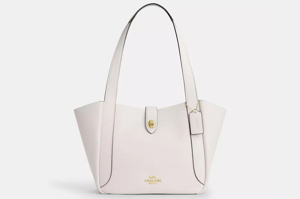 White Coach tote bag with a snap closure and gold-toned hardware.