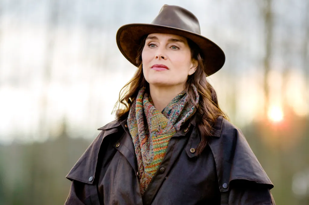 Brooke Shields as Charlotte Stanton in a brown duster coat and hat.