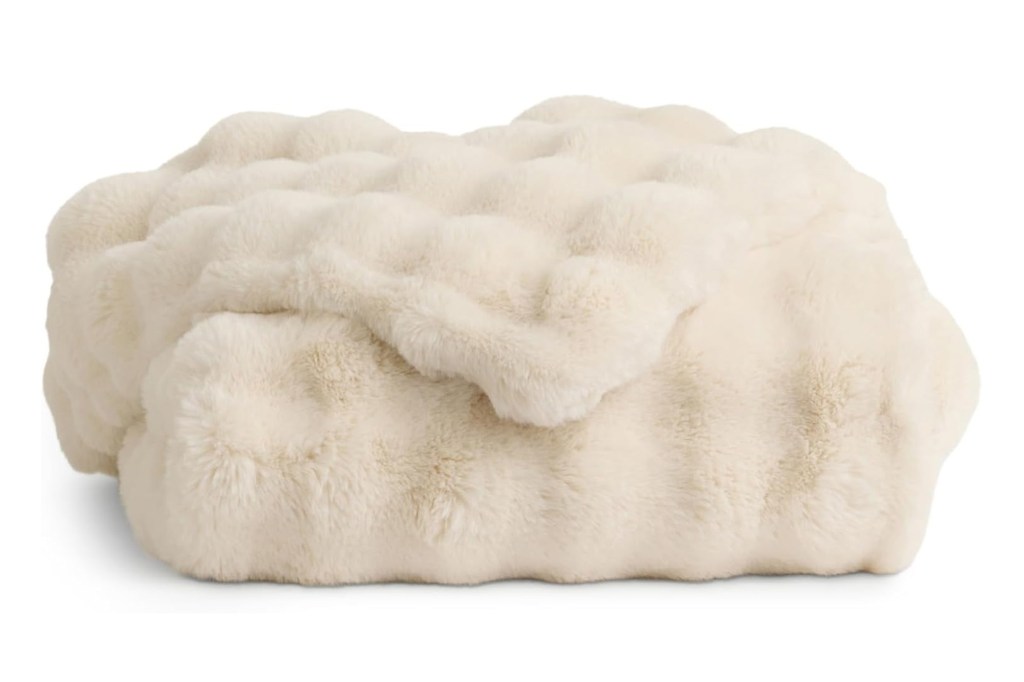 Off-white faux fur throw blanket.