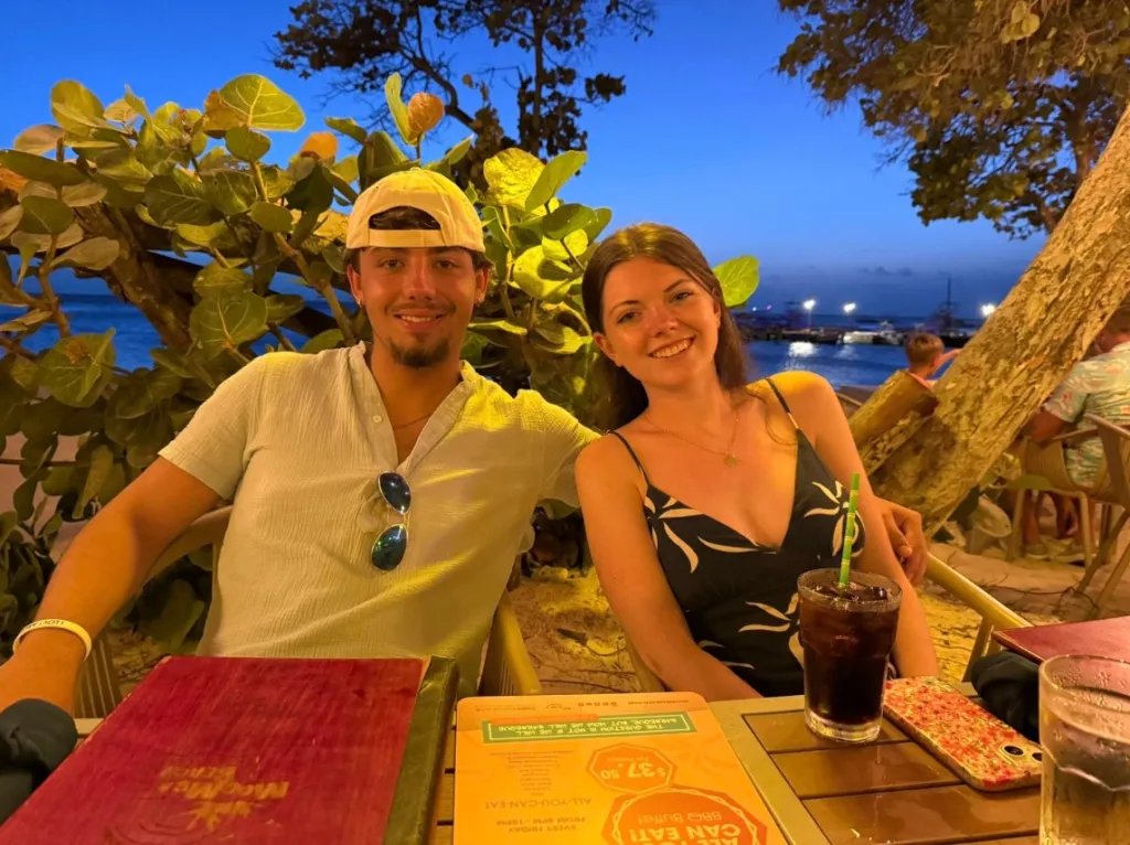 Emily Finn and Austin Lynch smiling at a restaurant table.