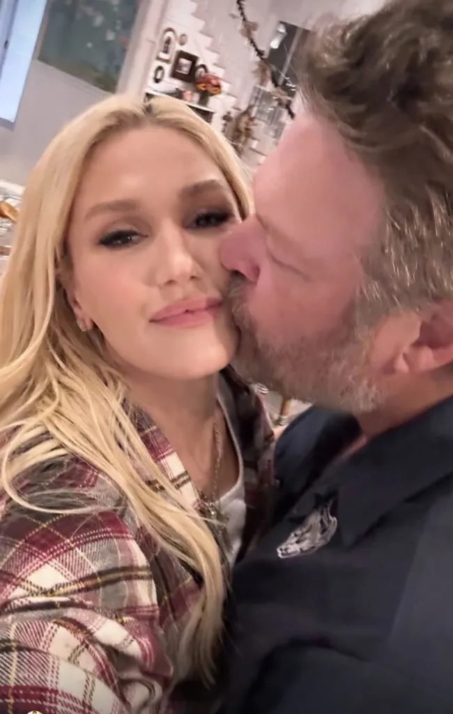 Gwen Stefani being kissed on the cheek by Blake Shelton.