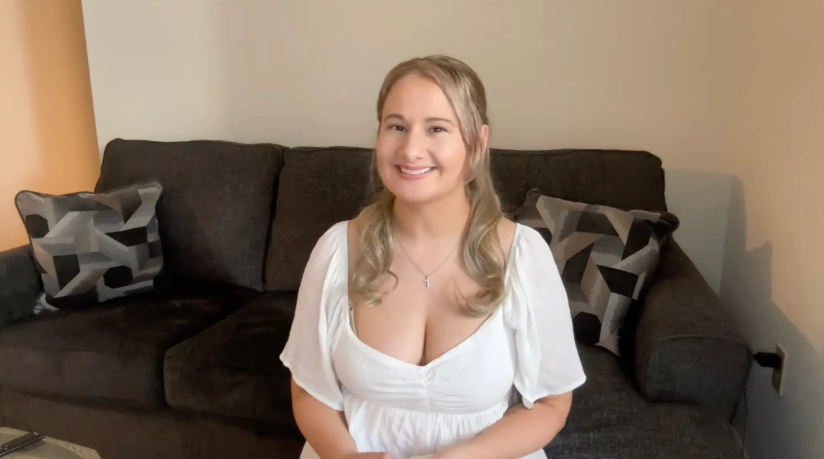 Gypsy Rose Blanchard smiling while sitting on a couch.