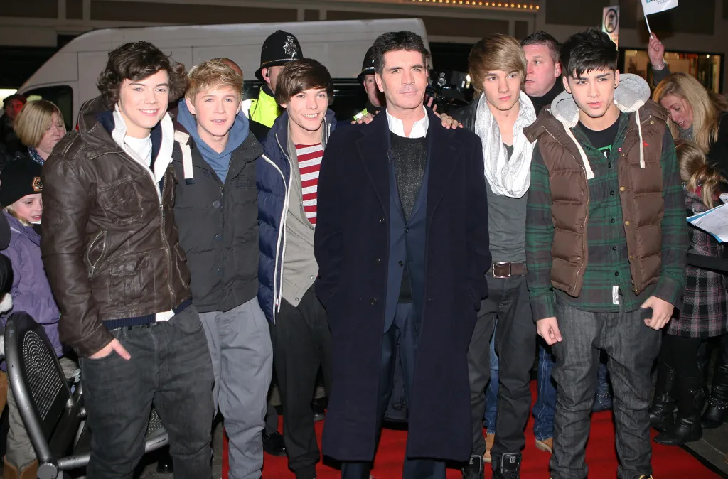 Harry Styles, Niall Horan, Louis Tomlinson, Simon Cowell, Liam Payne, and Zayn Malik of One Direction.