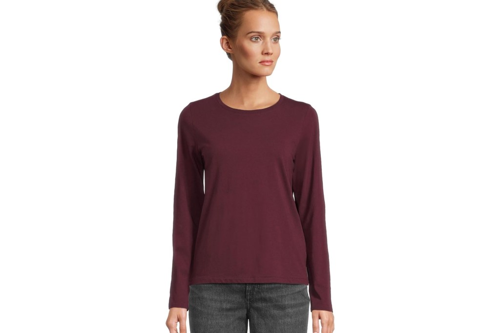 Woman wearing a burgundy long-sleeved Madewell t-shirt and dark jeans.
