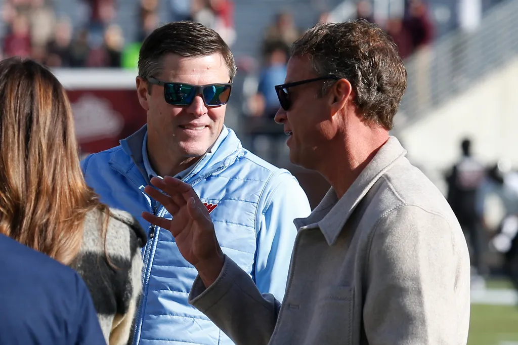 Mississippi Rebels head coach Lane Kiffin talking with athletic director Keith Carter.