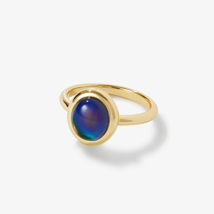 A gold ring with a color-changing stone in the center.