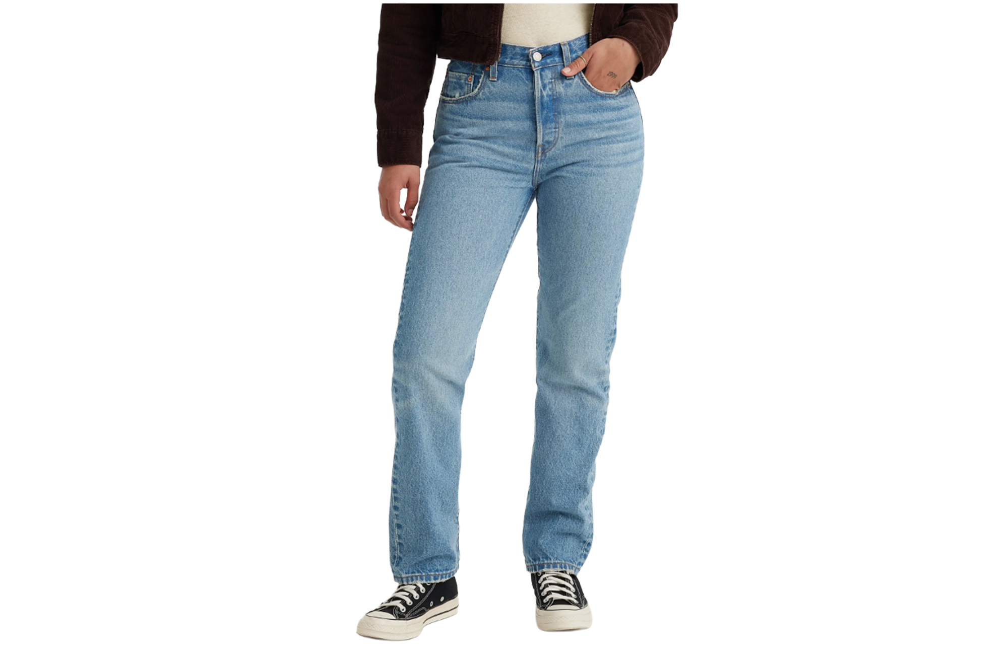 A woman wears straight-leg light-wash jeans, a brown jacket, and black sneakers.