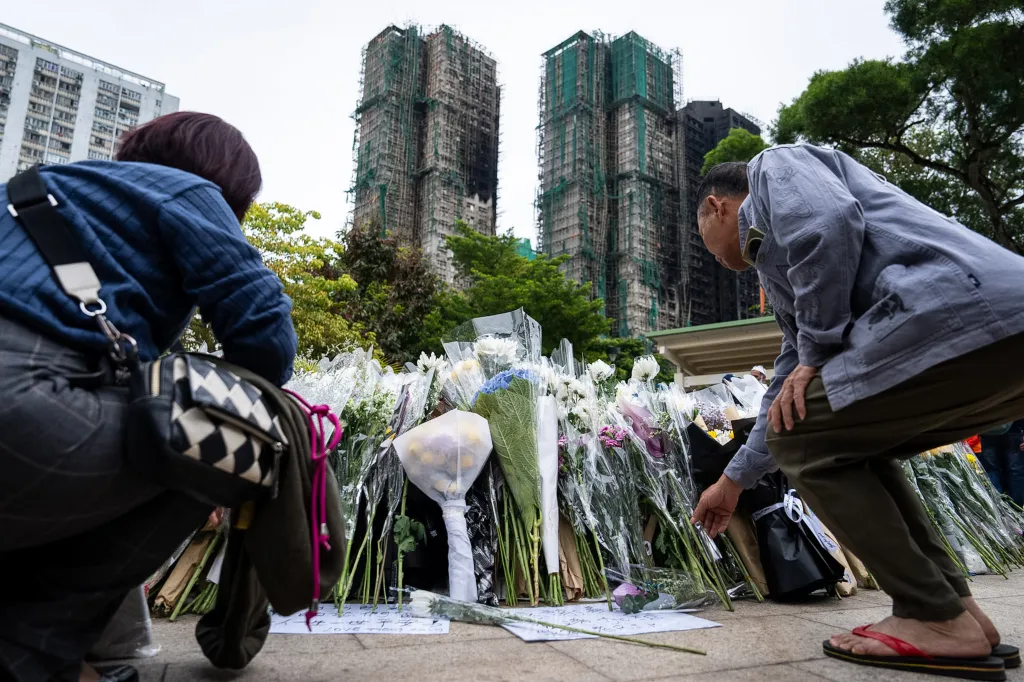 People place flowers at a memorial for the victims of the Hong Kong building fire on Nov. 30, 2025.